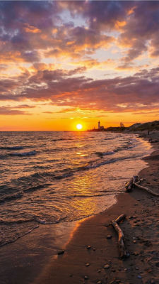 AI-generated sunset beach scene with lighthouse