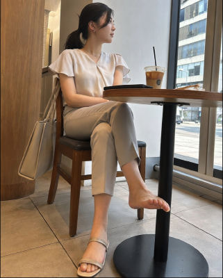 AI-generated image of a woman seated at a café with an iced coffee