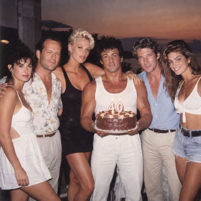 AI-generated image of Sylvester Stallone with Bruce Willis, Richard Gere, Demi Moore, Brigitte Nielsen, and Cindy Crawford at a birthday celebration