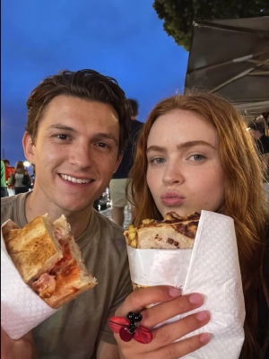 AI-generated image of Tom Holland and Sadie Sink eating at an outdoor event