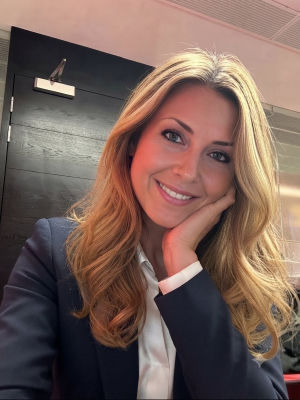 AI-generated portrait of a smiling blonde woman in a blazer