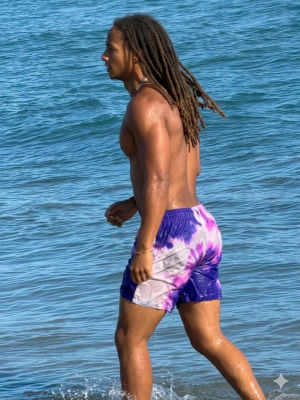 AI-generated image of Jaden Smith walking along the ocean in swim shorts