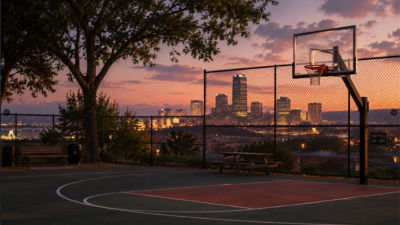 AI-generated image of an empty basketball court at sunset with a city skyline