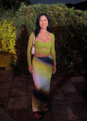 AI-generated image of a woman in a green lace top at an outdoor evening event