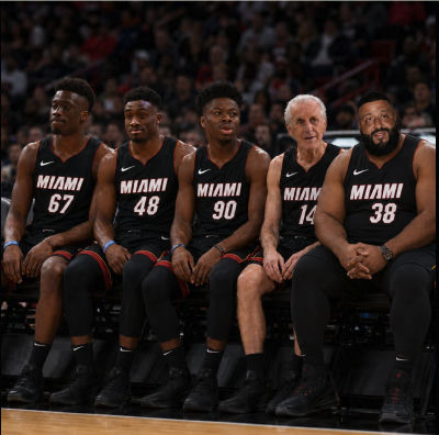 AI-generated image of DJ Khaled and Pat Riley seated in Miami Heat jerseys on team bench