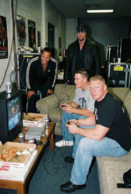 Deepfake image of The Undertaker, Dwayne Johnson, John Cena, and Brock Lesnar playing video games backstage