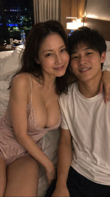 AI-generated image of a woman in a slip and a young man posing on a hotel bed