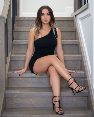 Deepfake of Ana de Armas seated on a staircase in a black dress