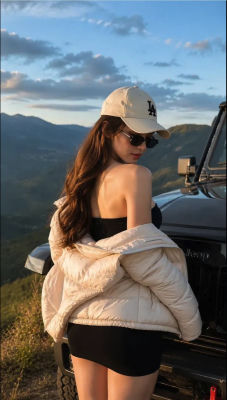 AI-generated image of a woman in an LA Dodgers cap beside a Jeep at a mountain overlook