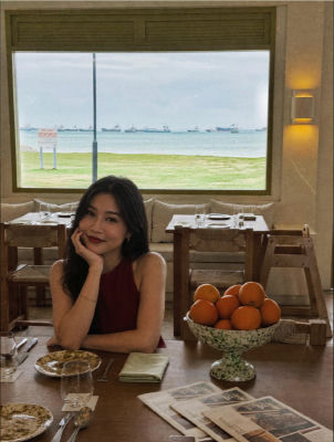 AI-generated photo of a woman at a waterfront restaurant with naval ships visible