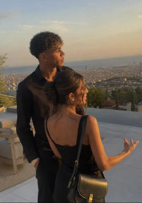 AI-generated photo of a Lamine Yamal at a terrace overlooking a city at sunset