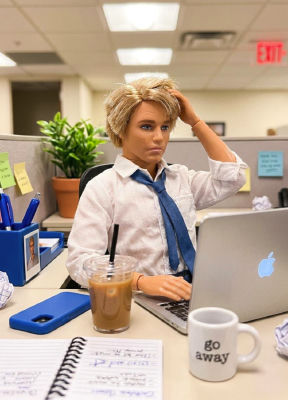 AI-generated image of a stylized doll-like figure at an office desk
