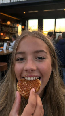 AI-generated selfie of an unidentified woman eating a stroopwafel