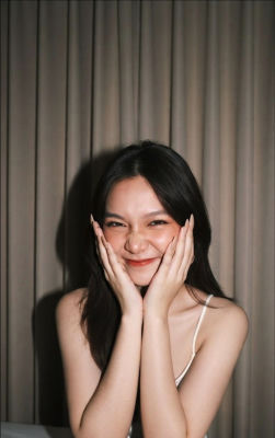 AI-generated portrait of a smiling woman with hands on her cheeks