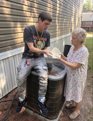AI-generated image of Jim Carrey handing cash to an elderly woman outdoors