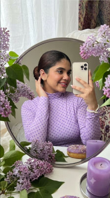 AI-generated mirror selfie of a woman styled with lilacs and purple candles