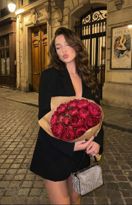 AI-generated image of a woman with red peonies on a Paris street