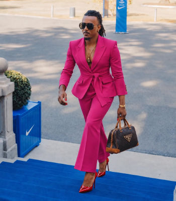 AI-generated image resembling Jules Koundé in a pink suit with a Prada bag