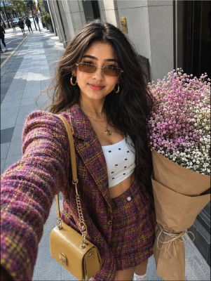 AI-generated selfie of a woman on a city sidewalk with a bouquet of flowers