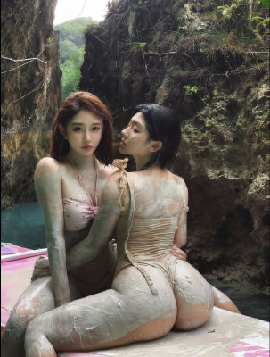 AI-generated image of two women in mud-covered bikinis on a paddleboard